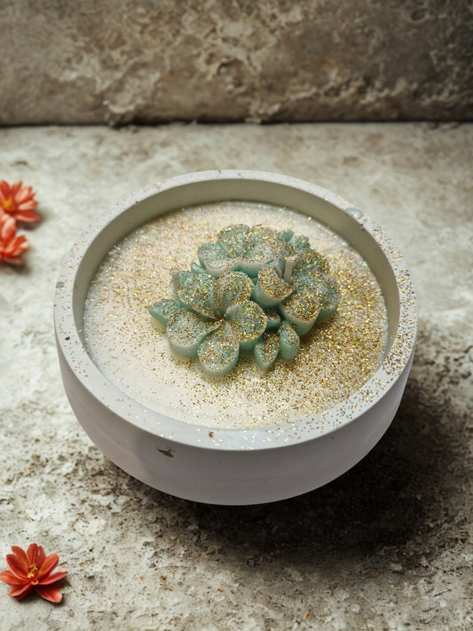 Vela redonda em gesso com flor verde e glitter dourado